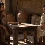 Recreación de dos hermanos conversando en un almacén de grano de la antigüedad.